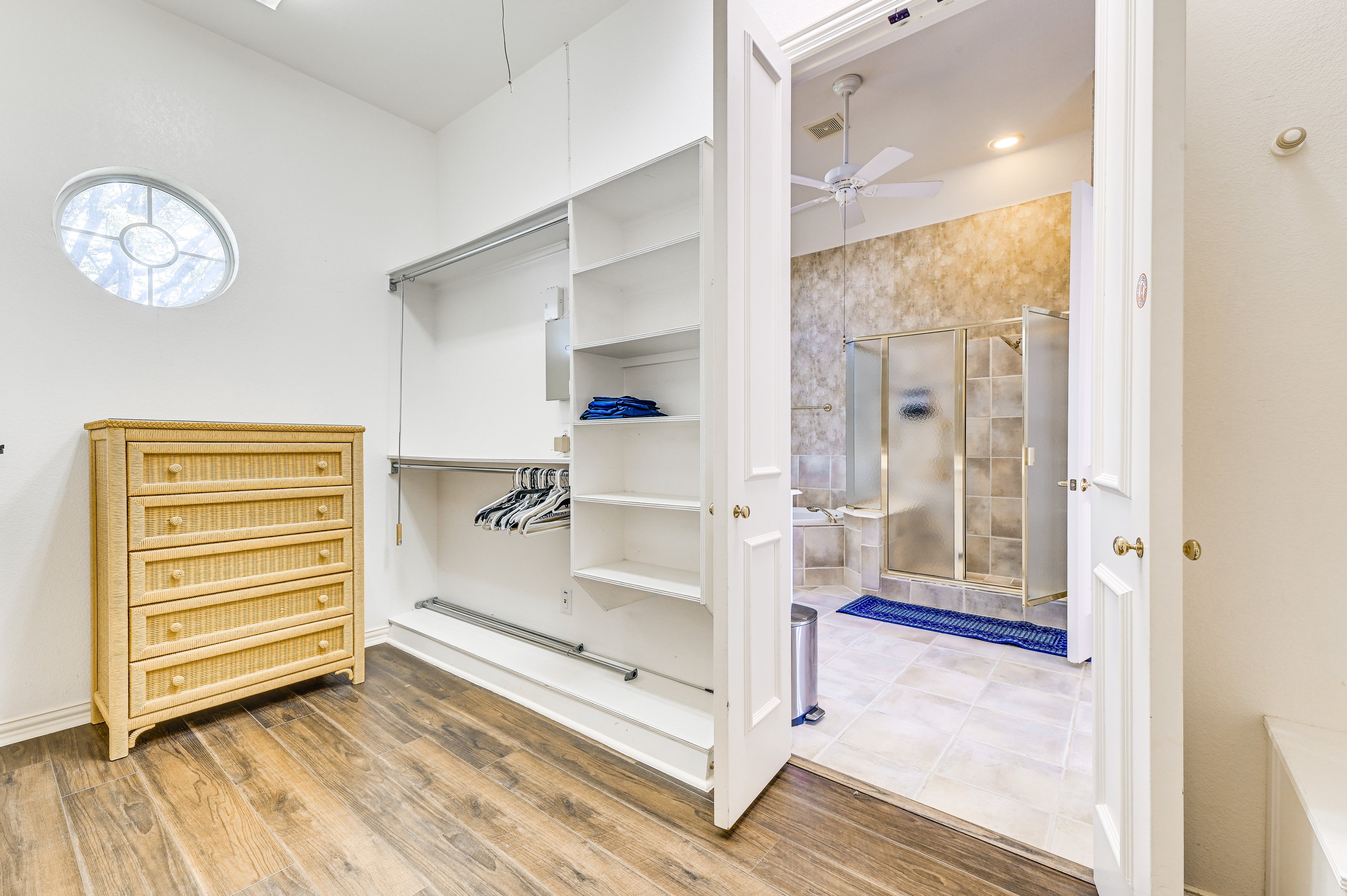 Shared Bedroom 1 — open closet with shelving and view into shared bathroom