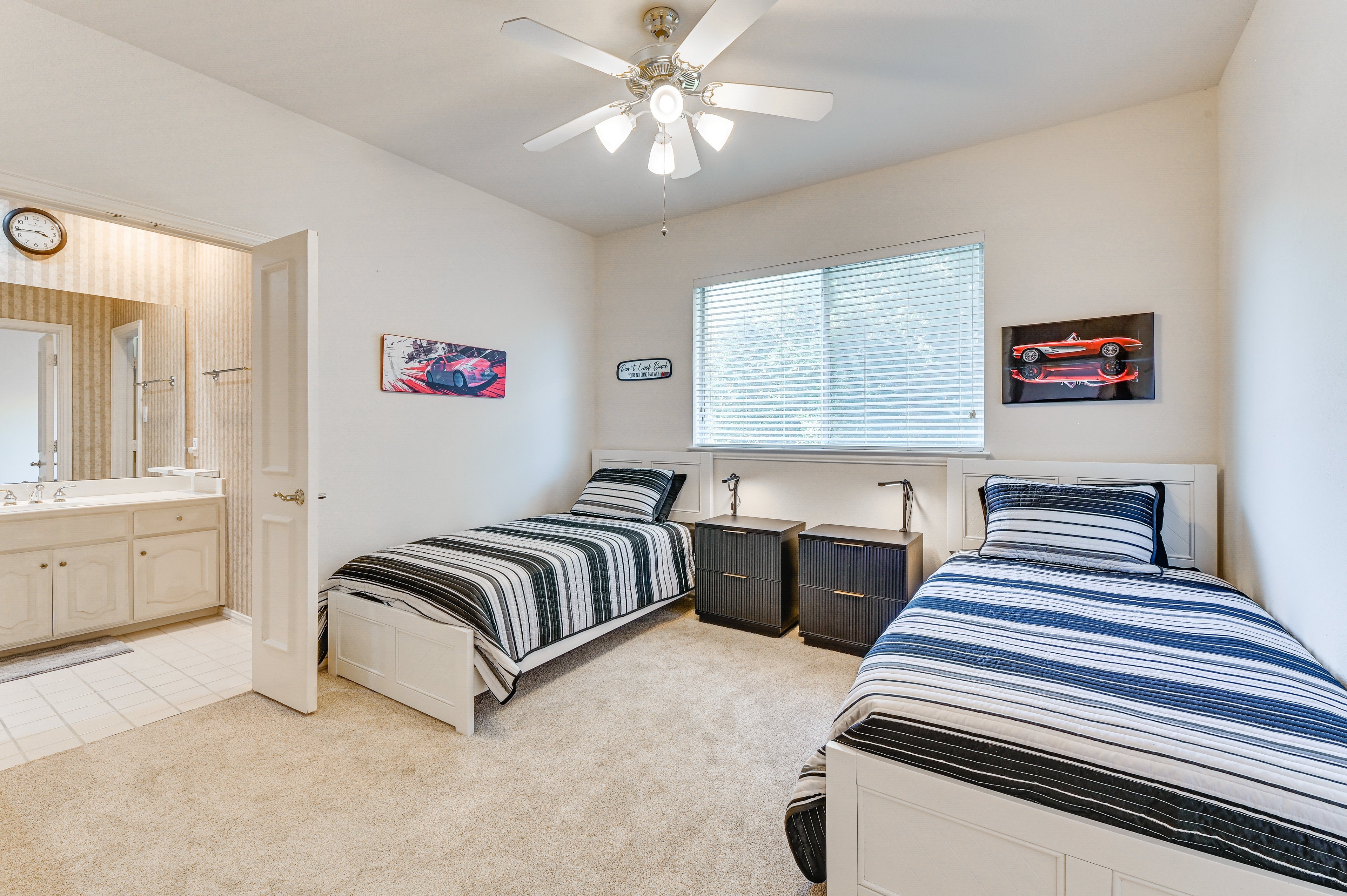 Shared Bedroom 6 — twin beds with blue and white striped bedding, ceiling fan, and shared bath access