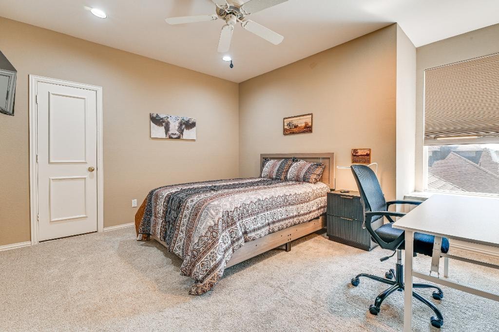 Private Suite Bedroom 5 — carpeted bedroom with ceiling fan and desk